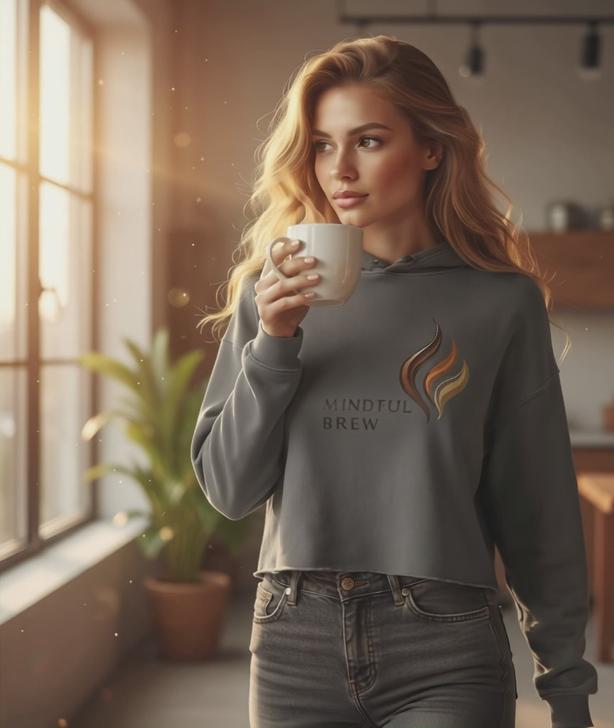 Woman model wearing HorizonVibe Mindful Brew storm gray cropped hoodie, sipping coffee in cozy morning sunlight, minimalist lifestyle