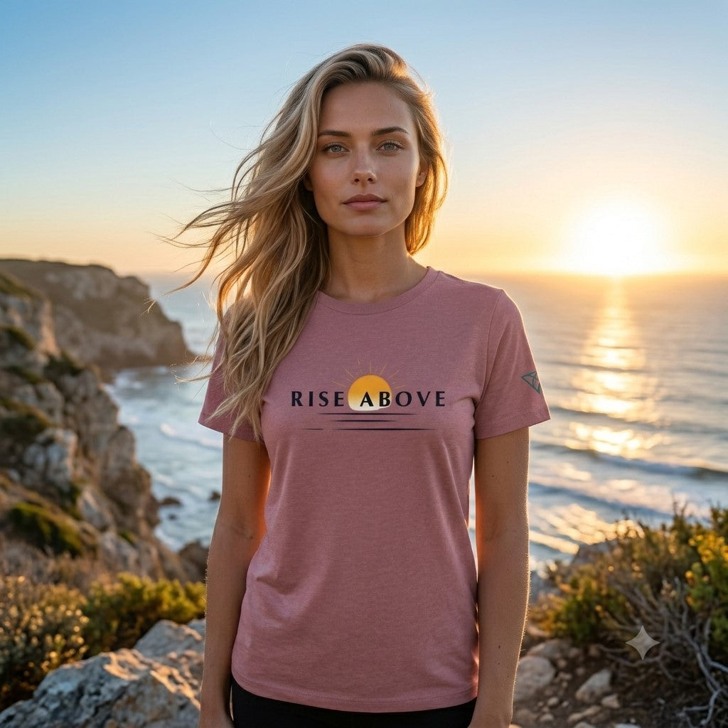 Woman standing on coastal cliffs at sunrise wearing the HorizonVibe Rise Above T-Shirt in Heather Mauve, overlooking the ocean with a calm, confident expression, capturing a peaceful outdoor lifestyle and positive mindset.